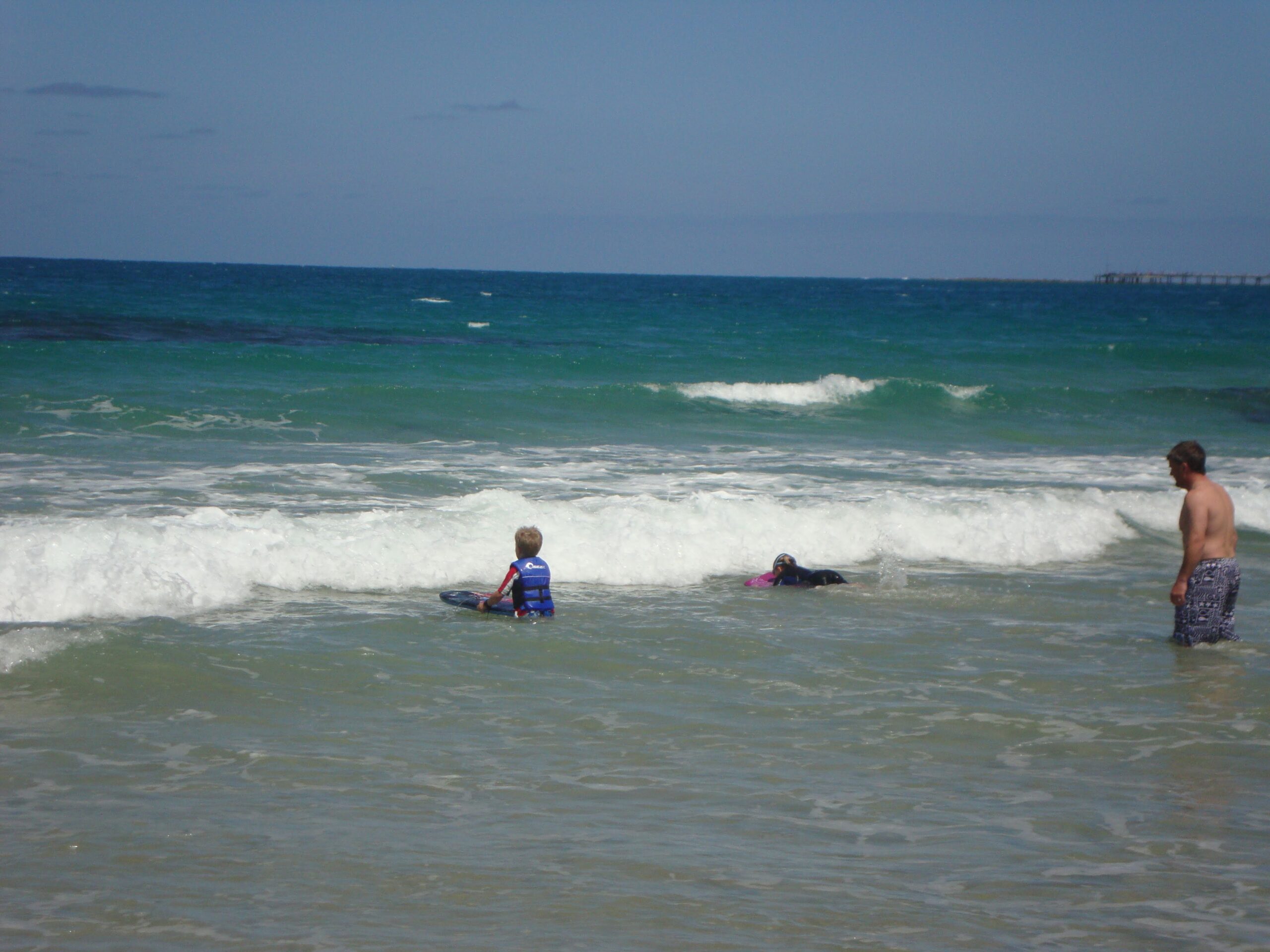 Rohan teaching Paddy and Keira how to surf at the beach many years ago